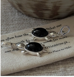 Vue macro détaillée de pendentifs tortue en argent plaqué avec incrustations d'onyx