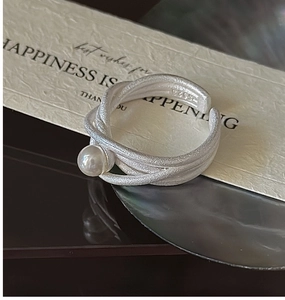 Dettaglio macro dell'anello in argento sterling S925 con finitura opaca e perla bianca