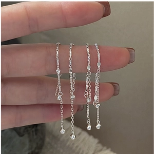 Detail of S925 sterling silver chain ring set with polished beads and textured charms