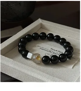 Macro shot of S925 silver beaded bracelet with black agate and rutilated quartz