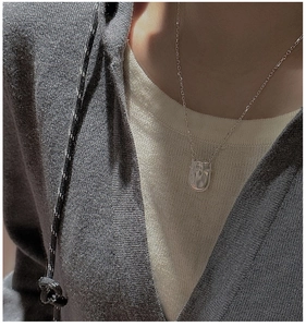 Gros plan du collier en argent S925 avec pendentif en U et texture de métal liquide