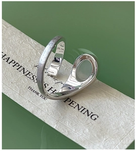 Detailed close-up of S925 sterling silver wrap ring with brushed finish and engraved logo