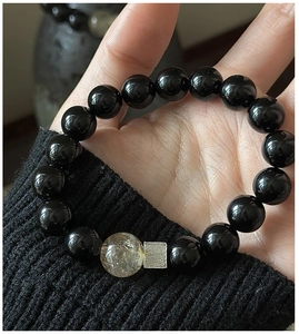 Close-up of S925 silver bracelet with black onyx beads and golden rutilated quartz