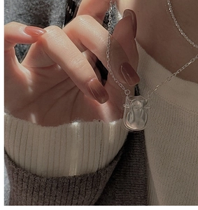 Détail d'un collier avec pendentif sac porte-bonheur en argent S925 à texture liquide