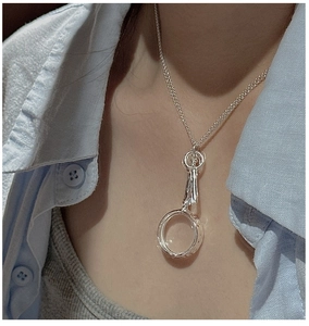 Close-up of S925 sterling silver necklace with textured round pendant worn on a model