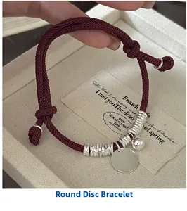Macro shot of S925 silver charms on red woven rope bracelet with adjustable knot
