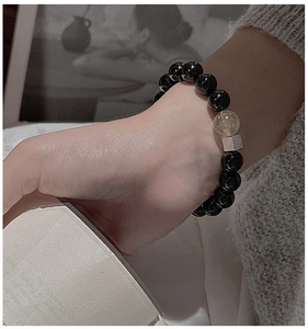 Detail of S925 silver bracelet with black onyx beads and rutilated quartz on wrist