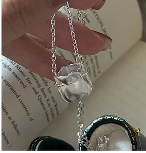 Gros plan détaillé d'un pendentif sac de chance en argent S925 sur chaîne élégante