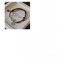 Detail of S925 sterling silver charms on red woven rope bracelet with adjustable slide