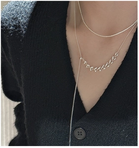 Detail of S925 sterling silver wheat ear Y-chain necklace worn on black knit fabric