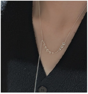 Detailed view of S925 silver tulip petal pendant chain worn on a black knit sweater