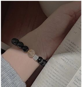 Close-up of S925 silver beaded bracelet with black onyx and rutilated quartz on a wrist