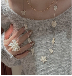 Detail of S925 sterling silver long necklace with ocean charms and pearl cluster ring