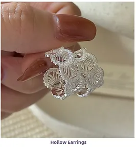 Detailed close-up showing the hollow-out lace texture of silver S925 earrings