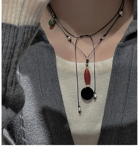 Close-up of S925 silver necklace with black, red and green agate beads on black cord