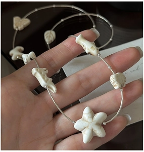 Detail of S925 silver sweater chain with carved beads like starfish and butterfly