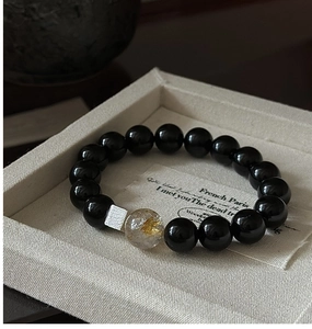 Detail of S925 silver bracelet featuring black onyx beads and gold rutilated quartz