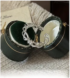 Detail of twisted S925 sterling silver rope ring in a green vintage jewelry box