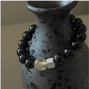 Close-up of S925 silver beaded bracelet with black agate and golden rutilated quartz