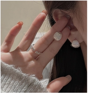 Close-up of S925 sterling silver star earrings and gothic hollow letter ring on a model