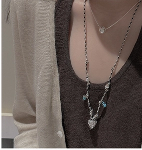 Détail du collier superposé en argent S925 et cordon tressé boho avec pendentif en cœur