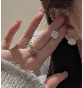 Detailed view of silver star stud earrings with brushed texture and zircon accents
