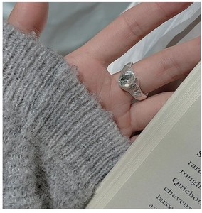 Detail of vintage textured silver ring with large oval zircon on a lifestyle background