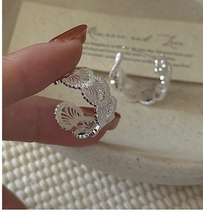 Detailed close-up of S925 sterling silver hoop earrings with intricate lace texture