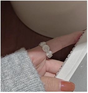 Detailed view of silver starburst medallion ring featuring vintage embossed textures