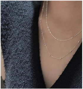 Détail de colliers superposés en argent sterling S925 avec chaînes à billes et textures