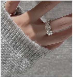 Macro detail of S925 silver ring featuring rustic rock texture and star engraving design