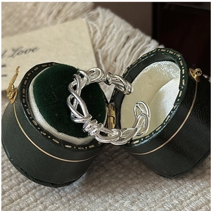 Close-up of S925 sterling silver braided ring inside a vintage green jewelry box