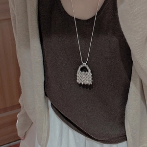 Detail of S925 sterling silver beaded necklace with unique handbag shaped pendant on a model