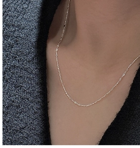 Gros plan d'un collier en argent S925 avec pendentif fer à cheval porté au ras du cou