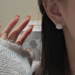 Minimalist S925 sterling silver star stud earrings with brushed texture on model's ear