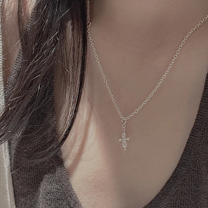 Close-up of S925 silver star pendant with freshwater pearl on a brown knit sweater