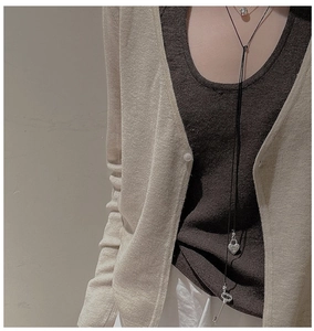 Détail du collier S925 en argent avec serrure en cœur et clé sur un pull en maille