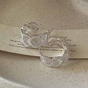 S925 sterling silver C-shaped earrings with vintage lace texture in a macro shot