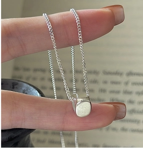 Macro shot of S925 sterling silver cylindrical pendant on a delicate chain necklace