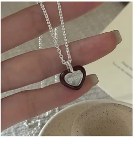 Close-up of S925 sterling silver heart pendant with red enamel and cursive engraving