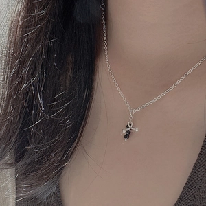 Minimalist S925 silver necklace with cross pendant and black beads on a female model