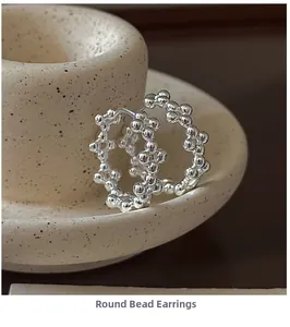 Vue détaillée des créoles en argent sterling perlé sur décor en céramique épuré