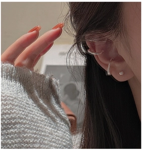 Close-up of stylish silver ear cuffs and bead stud earring on model's ear