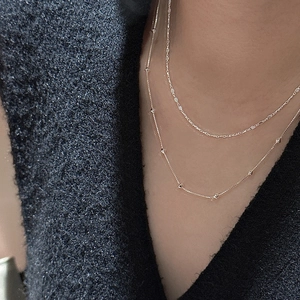 Collier double rang en argent S925 doré avec pendentifs géométriques sur pull en maille