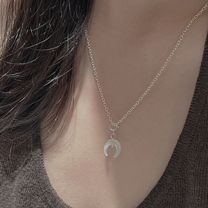 Détail du collier croissant de lune en argent s925 sur modèle avec texture translucide