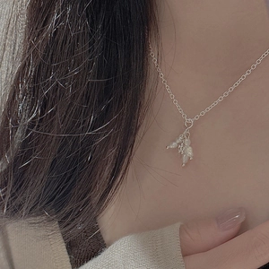 Detail of s925 silver flower pendant necklace with pearls on neck for a minimalist look