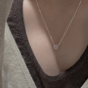 Minimalist S925 sterling silver necklace with bean pendant on a woman's neck