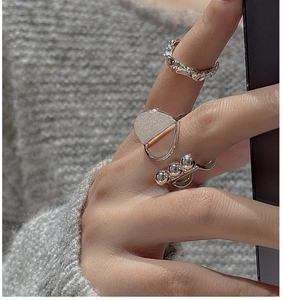Detailed view of three stacked S925 sterling silver rings with brushed and textured beads
