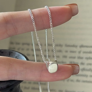 Minimalist S925 sterling silver chain with a polished cylindrical pendant held in hand