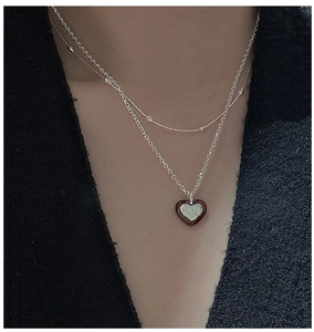 Detail of S925 sterling silver double-layered heart necklace with red enamel finish